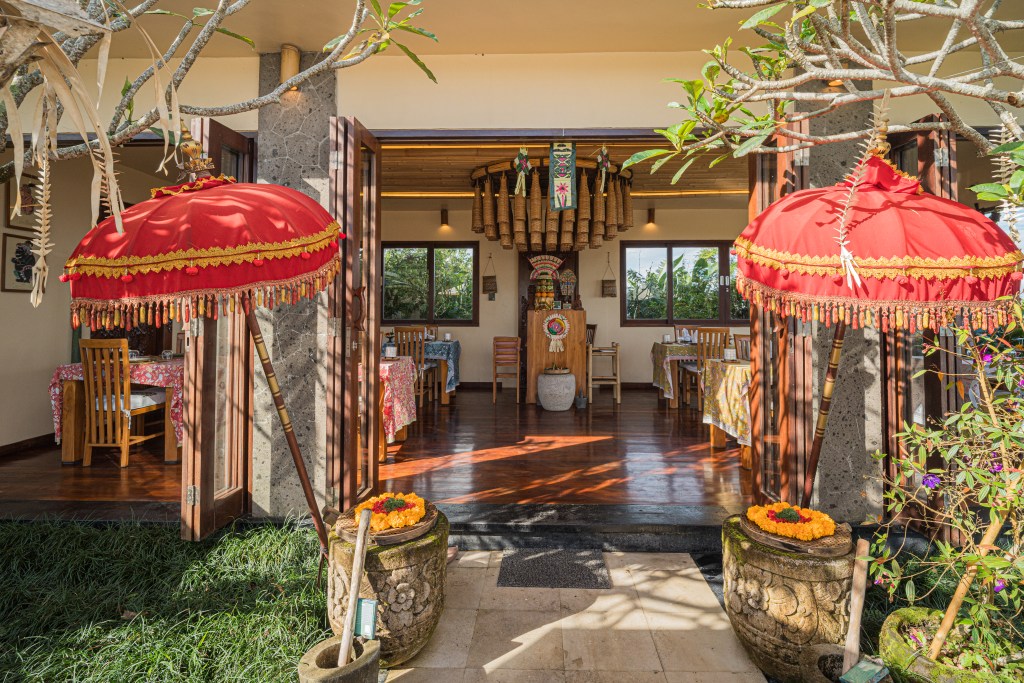 Entrée du restaurant Warung Bongkot avec ombrelles balinaises dans un cadre tropical à Munduk Bali